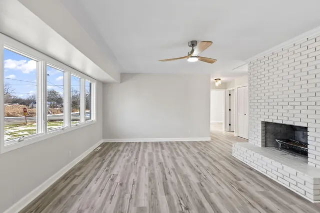 wooden floor fireplace and windows in an empty room