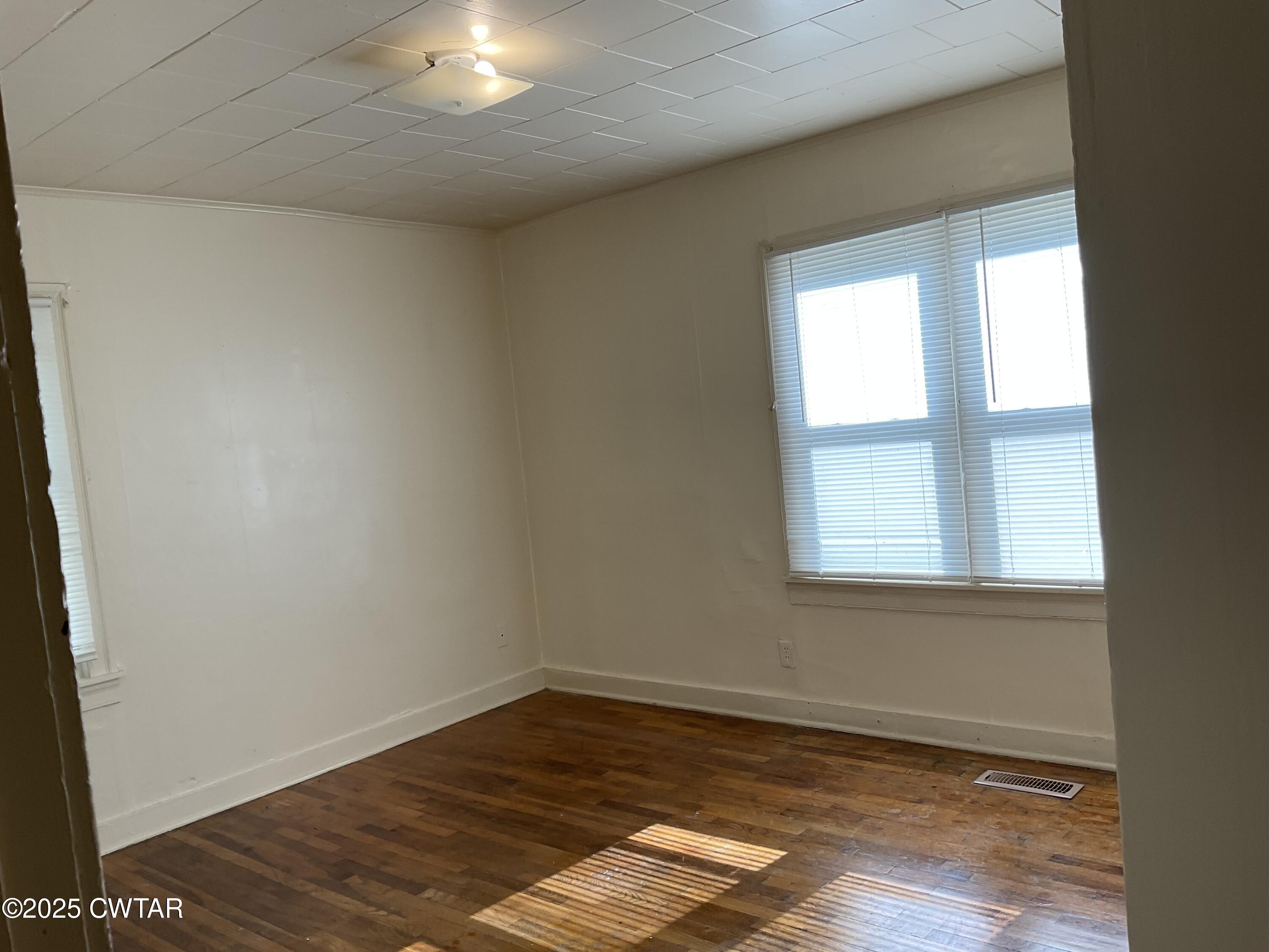 124 Muse Street Jackson, TN 38301 - Photo 12 of 14 an empty room with wooden floor and windows