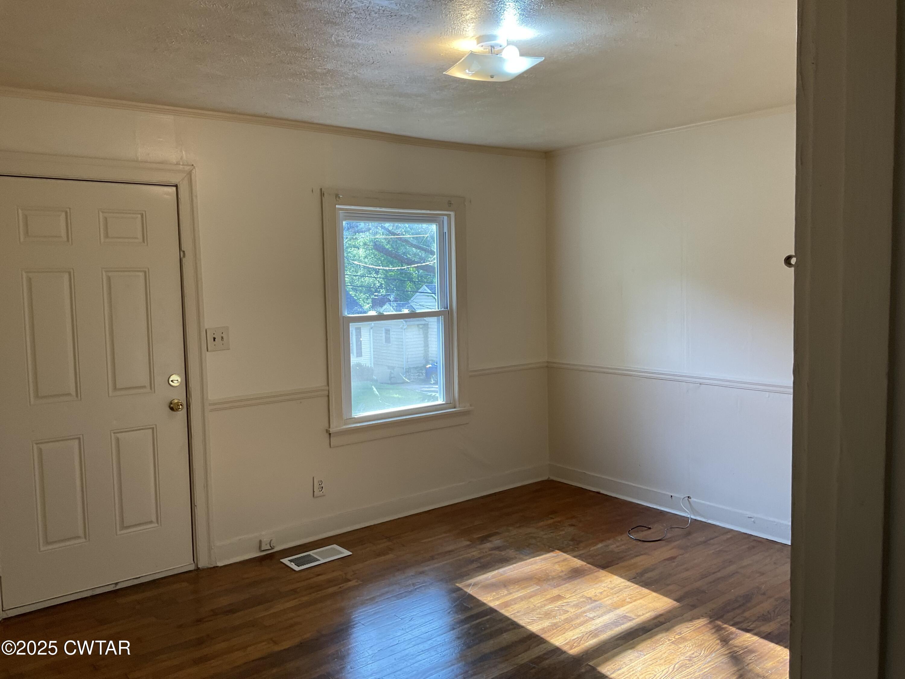 124 Muse Street Jackson, TN 38301 - Photo 9 of 14 an empty room with wooden floor cabinet and windows
