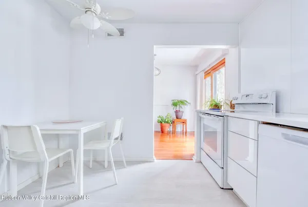 a kitchen with white cabinets and white appliances