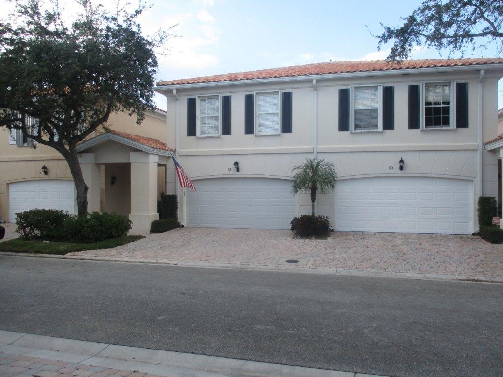 a white house that has a tree in front of it