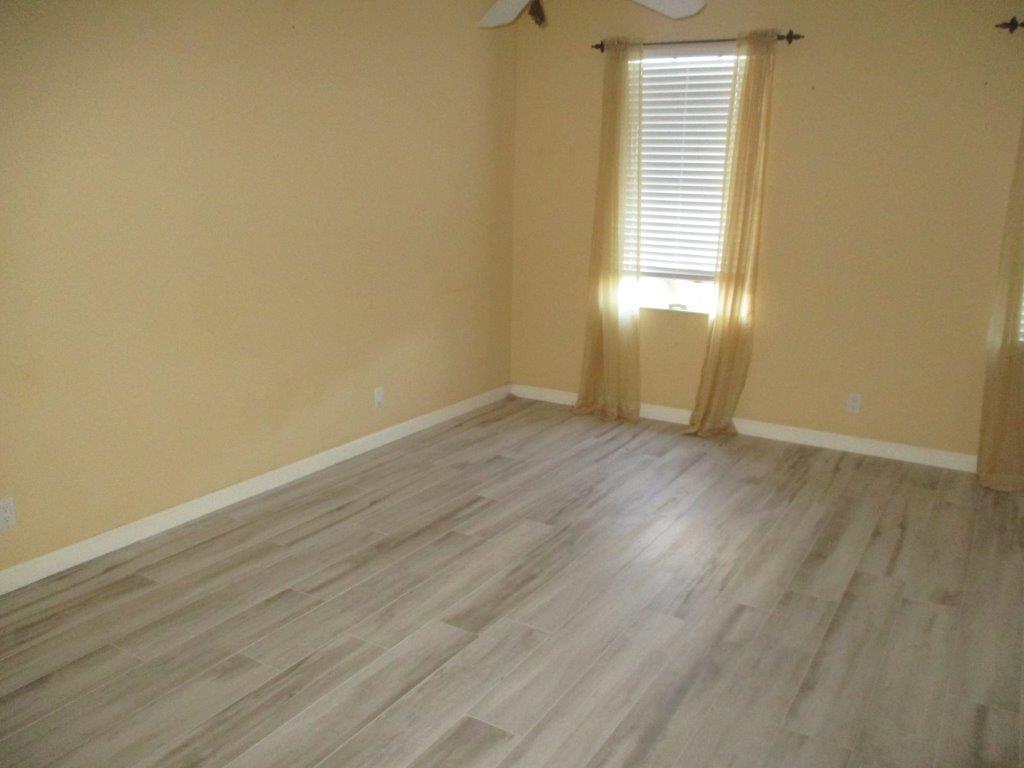 57 Laurel Oaks Circle Tequesta, FL 33469 - Photo 10 of 18 an empty room with wooden floor and windows