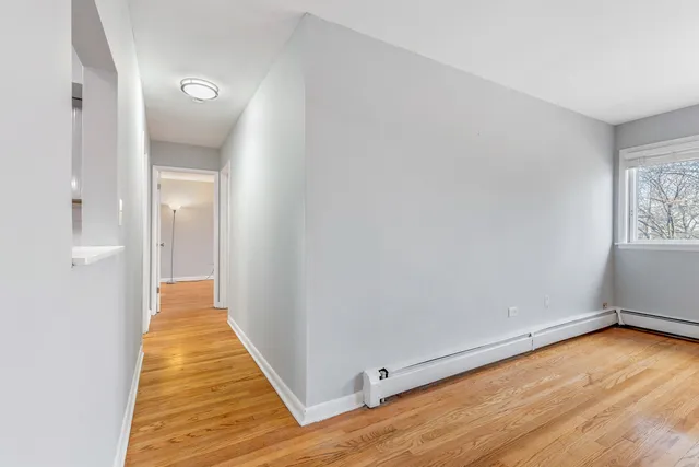 a view of a room with wooden floor and a hallway