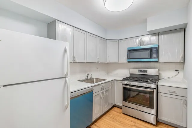 a kitchen with white cabinets and white appliances