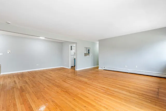 a view of an empty room with wooden floor