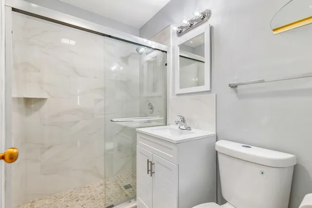 a bathroom with a sink a toilet and shower