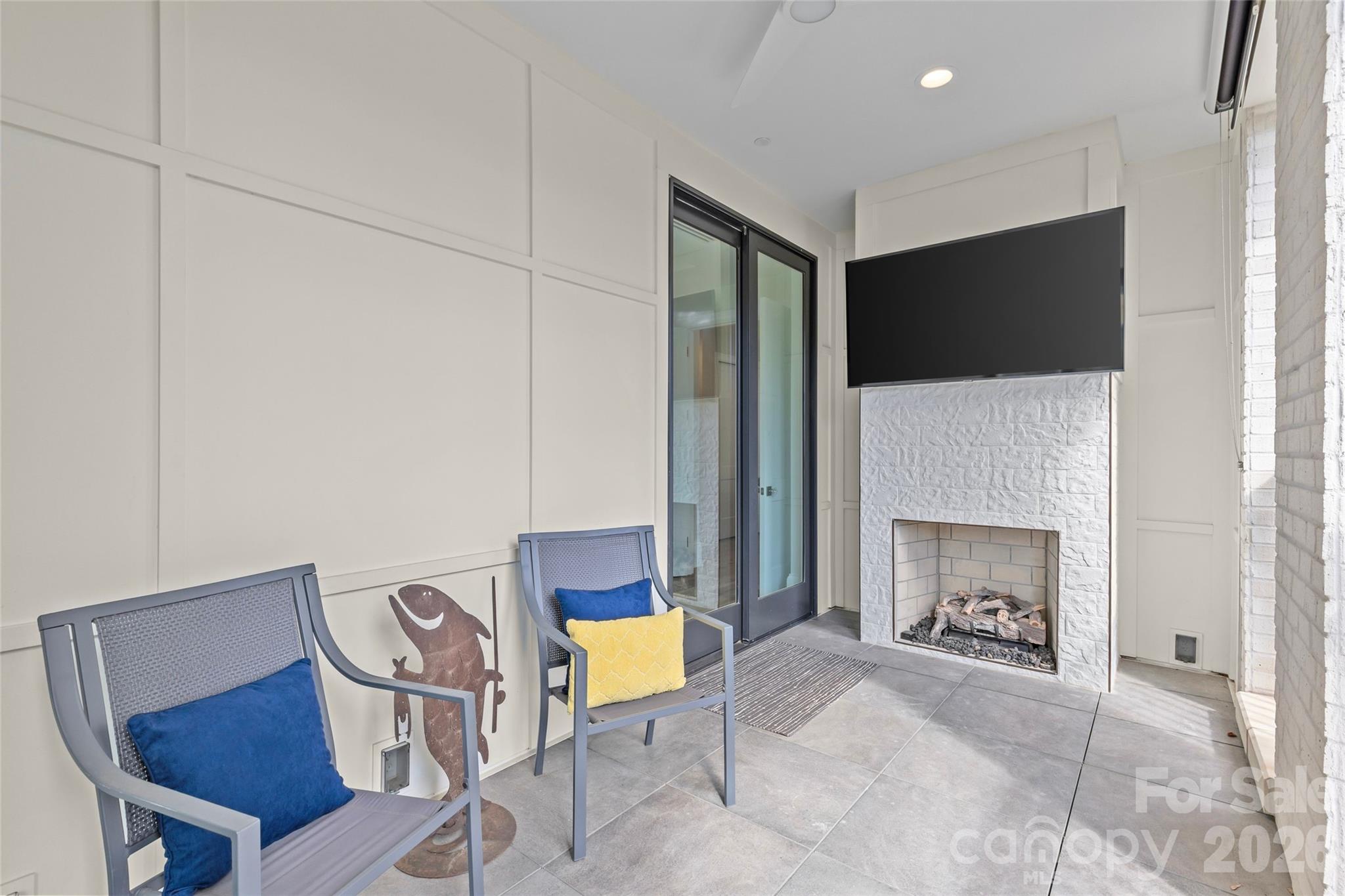 1500 Queens Road, Unit 104 Charlotte, NC 28207 - Photo 31 of 41 a living room with furniture a fireplace and a flat screen tv