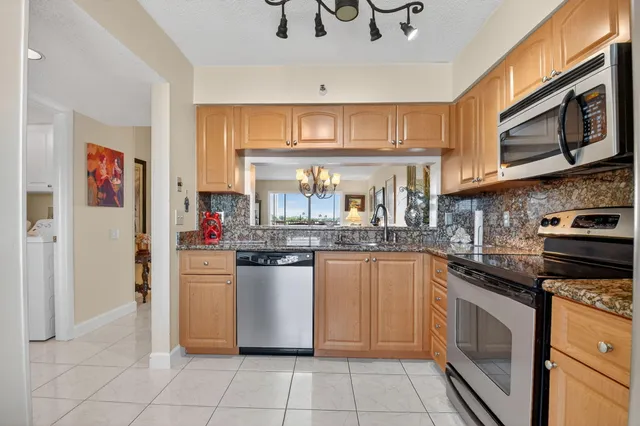 a kitchen with stainless steel appliances granite countertop a sink and a stove