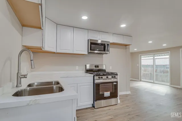 a kitchen with a sink a stove and microwave