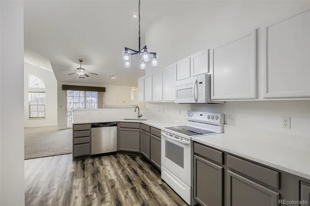 a kitchen with kitchen island granite countertop stainless steel appliances a sink stove and cabinets