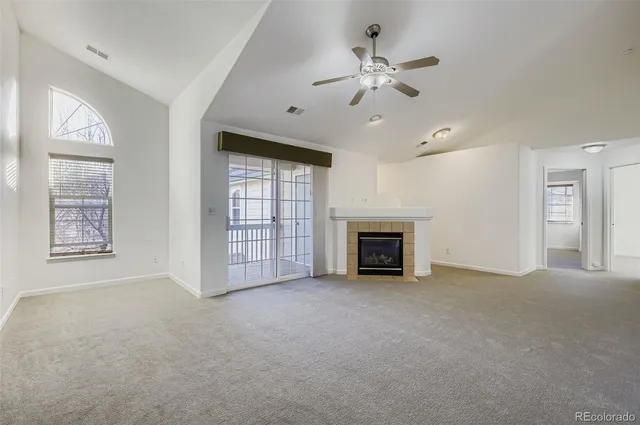 an empty room with windows and fireplace