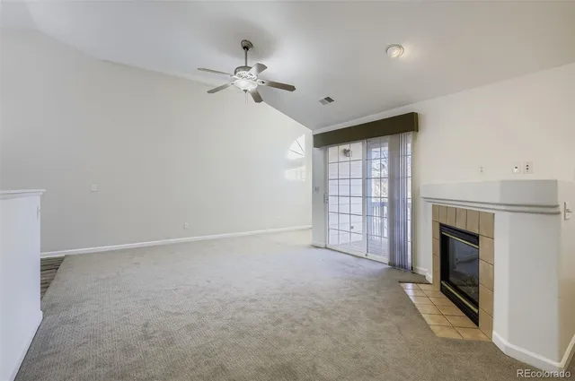 a view of an empty room with a fireplace and a window