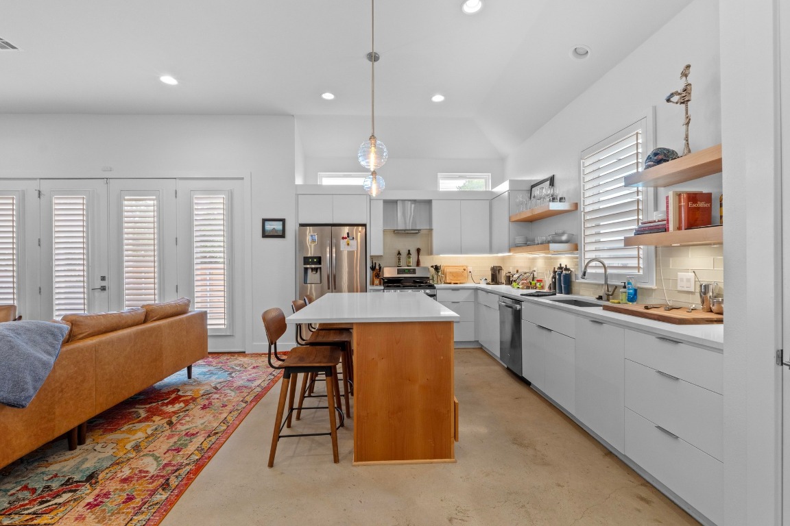 4801 Louis Avenue, Unit 1 Austin, TX 78721 - Photo 11 of 26 Kitchen featuring modern cabinets, backsplash, a kitchen bar, a kitchen island, and recessed lighting