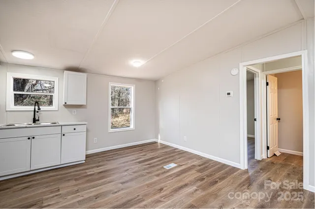 a view of a kitchen and a sink a window and wooden floor
