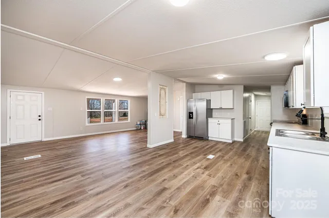 a view of a kitchen with wooden floor and windows