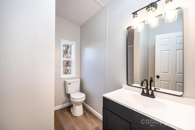 a bathroom with a sink a toilet and a mirror