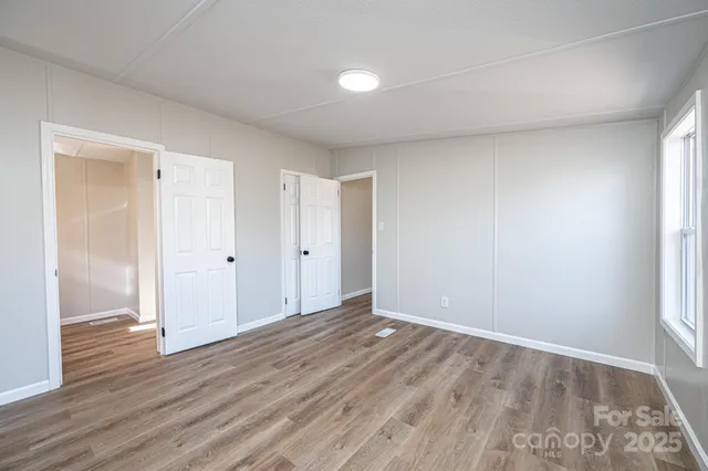 a view of an empty room with wooden floor