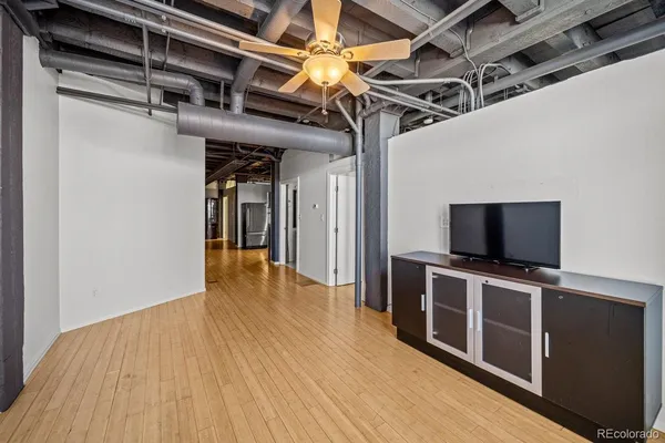a view of a livingroom with wooden floor and a flat screen tv