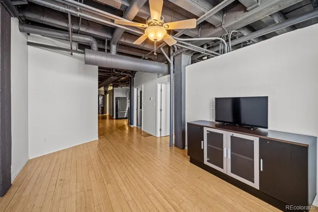 a view of a livingroom with wooden floor and a flat screen tv