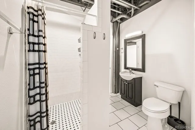 a bathroom with a toilet a sink and shower
