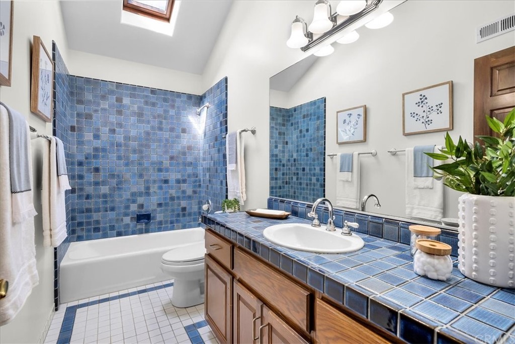 263 Park Avenue Long Beach, CA 90803 - Photo 51 of 67 a bathroom with a granite countertop sink a toilet a mirror a vanity a bath tub and shower