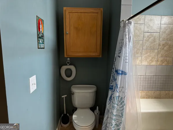 a bathroom with a toilet and a shower