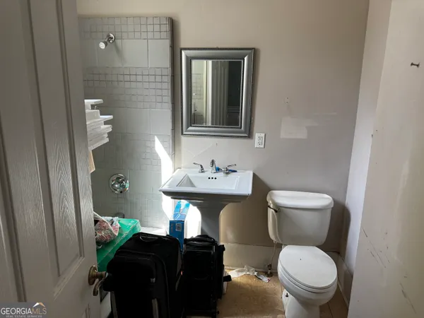 a bathroom with a toilet a sink and mirror