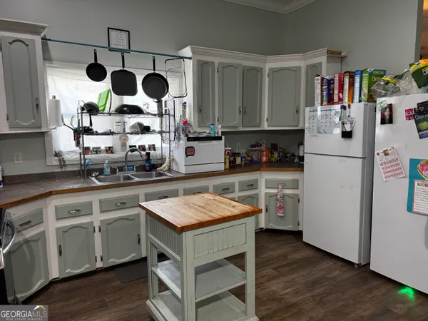 a kitchen with refrigerator a stove a sink and cabinets