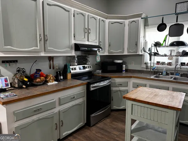 a kitchen with stainless steel appliances granite countertop a sink a stove and cabinets