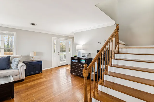 a view of a livingroom with a chandelier fan and windows