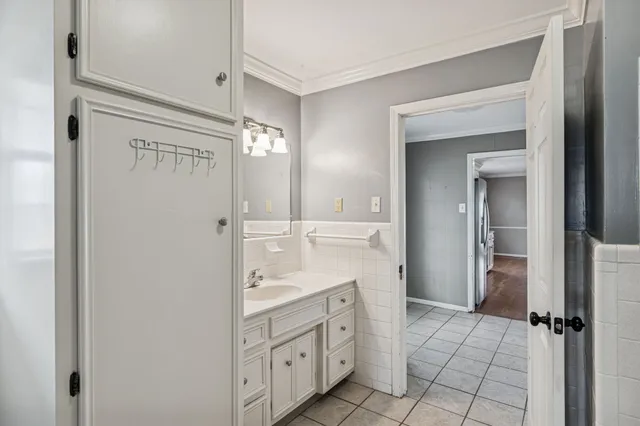 a kitchen with stainless steel appliances granite countertop a stove a sink a refrigerator with white cabinets and wooden floor