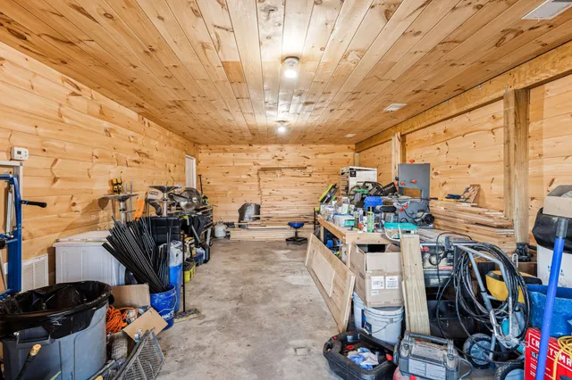 a living room with stainless steel appliances kitchen island granite countertop furniture and a rug