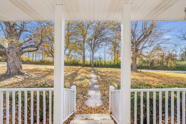 a view of a hallway with wooden floor and living room