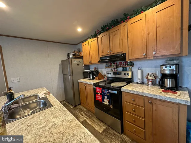 a kitchen with granite countertop a refrigerator stove and sink