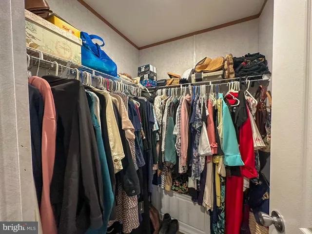 a view of walk in closet with clothes