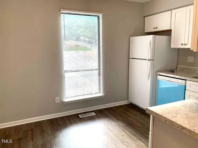 a kitchen with granite countertop white cabinets and white appliances