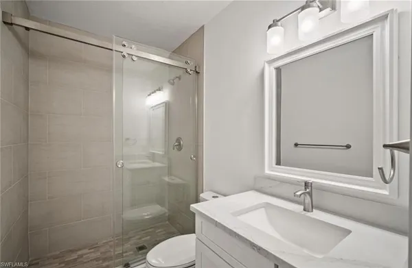 a bathroom with a sink toilet a mirror and shower
