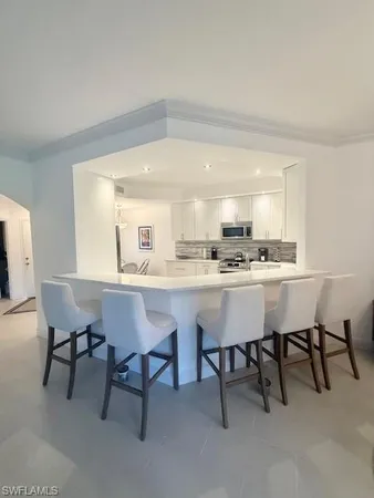 a room with a table chairs and a kitchen view