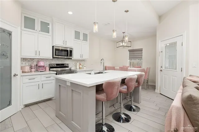 a kitchen with granite countertop a sink appliances cabinets and furniture