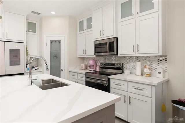a kitchen with stainless steel appliances a stove microwave and sink