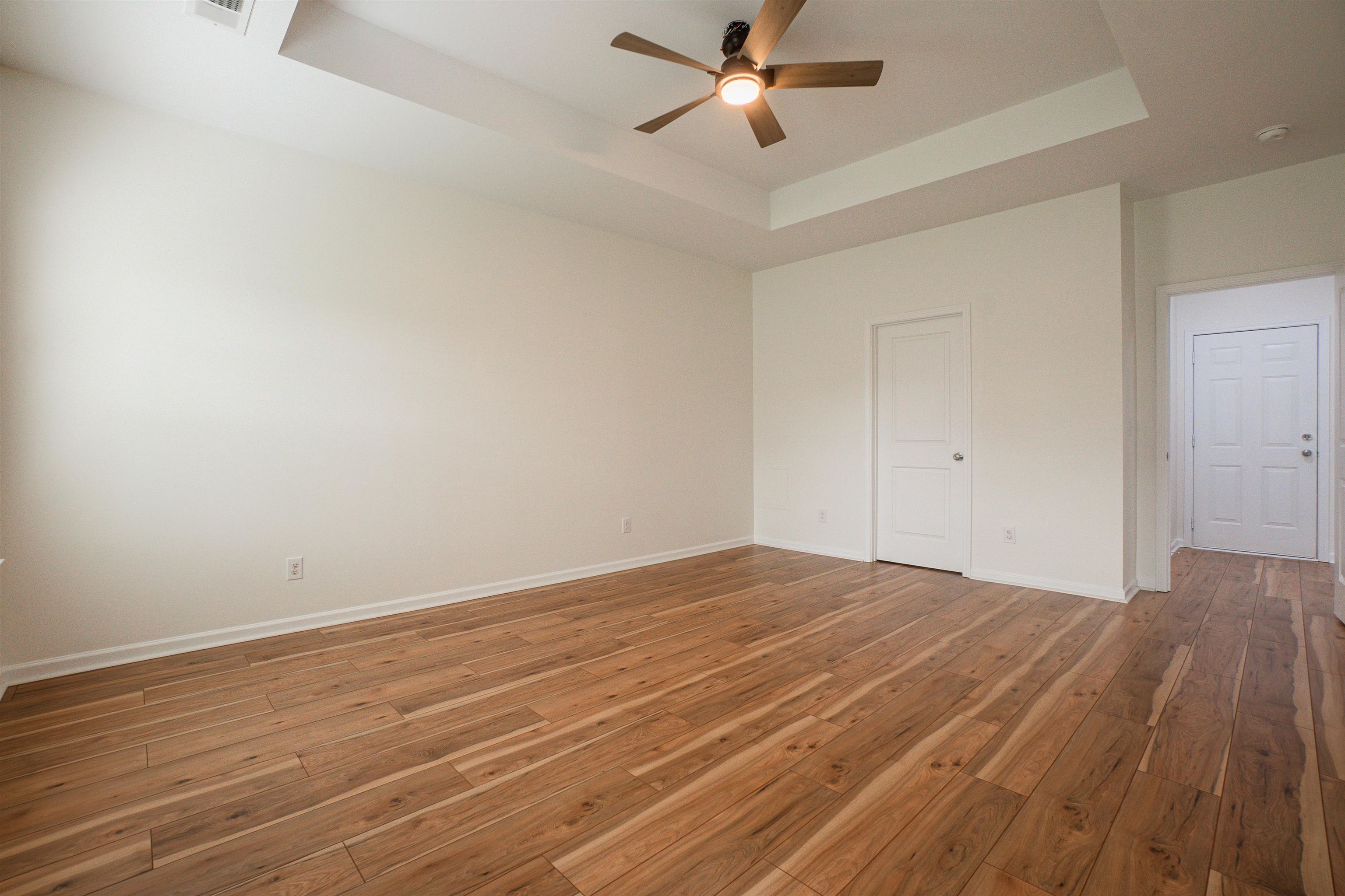 1752 Musket Trail Sumter, SC 29150 - Photo 13 of 37 Unfurnished bedroom featuring hardwood / wood-style floors, ceiling fan, and a tray ceiling