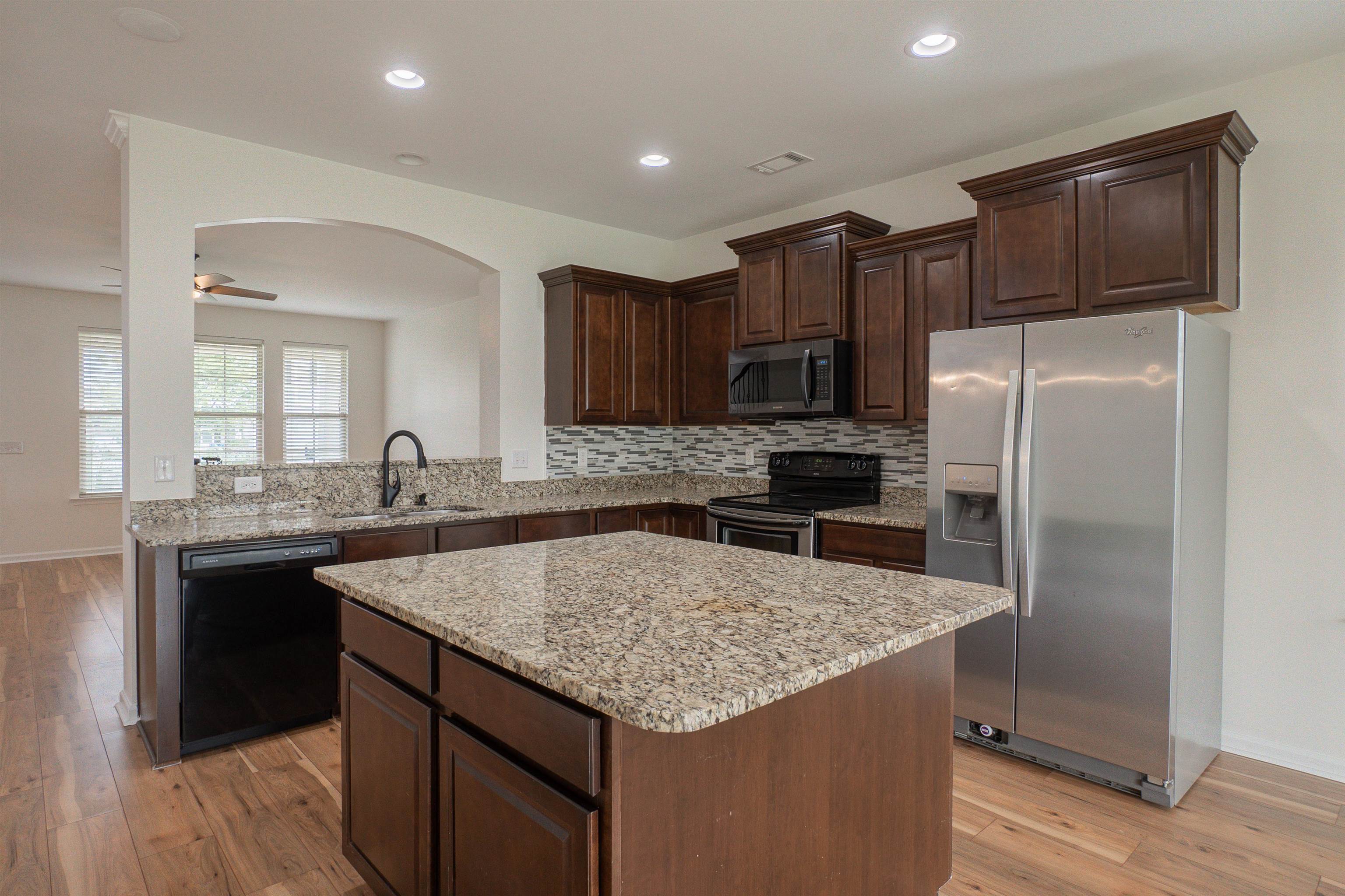 1752 Musket Trail Sumter, SC 29150 - Photo 5 of 37 Kitchen with appliances with stainless steel finishes, light stone countertops, dark brown cabinetry, light wood-style floors, and recessed lighting