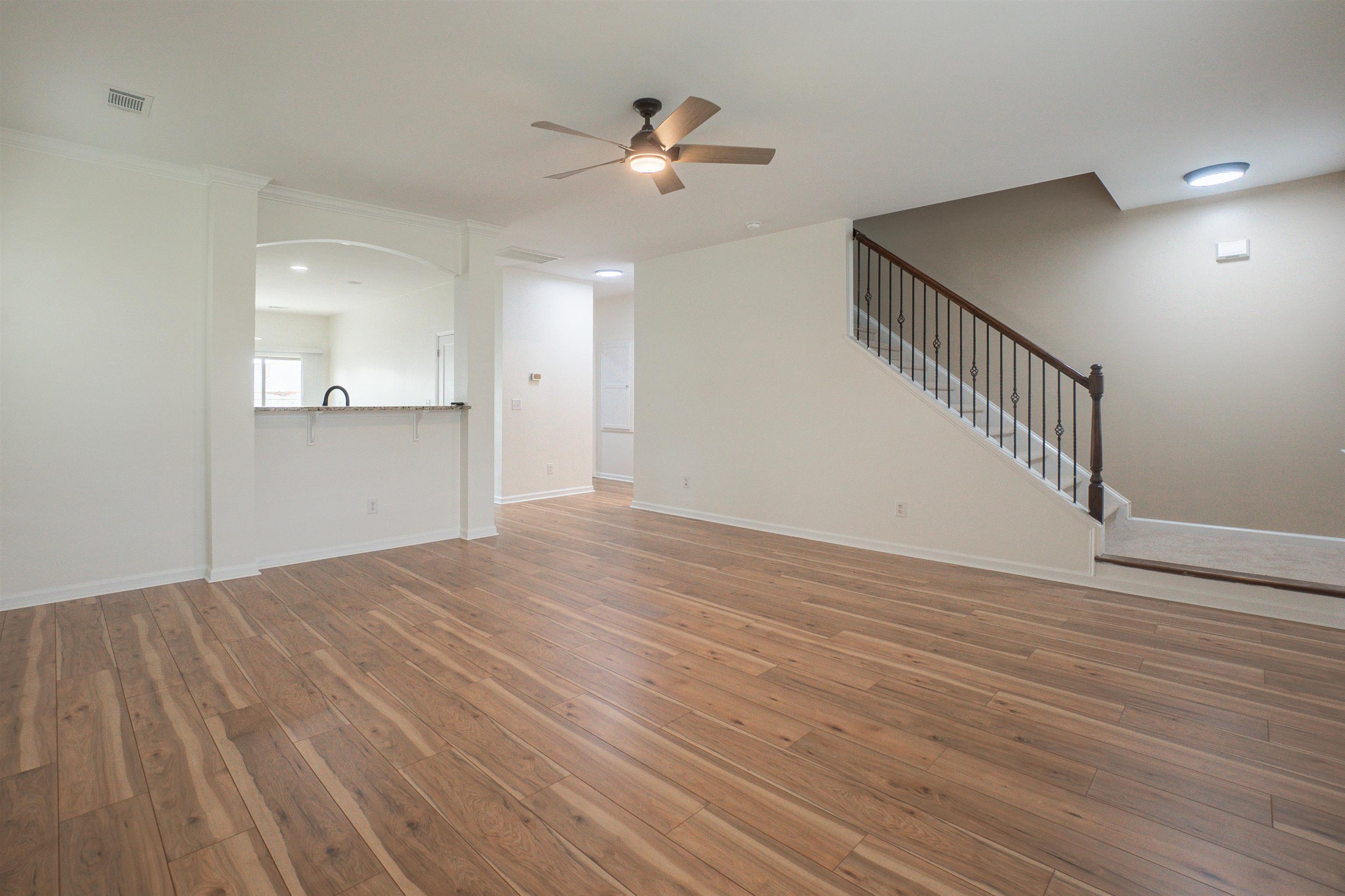 1752 Musket Trail Sumter, SC 29150 - Photo 8 of 37 Unfurnished living room featuring stairway, light wood finished floors, and ceiling fan