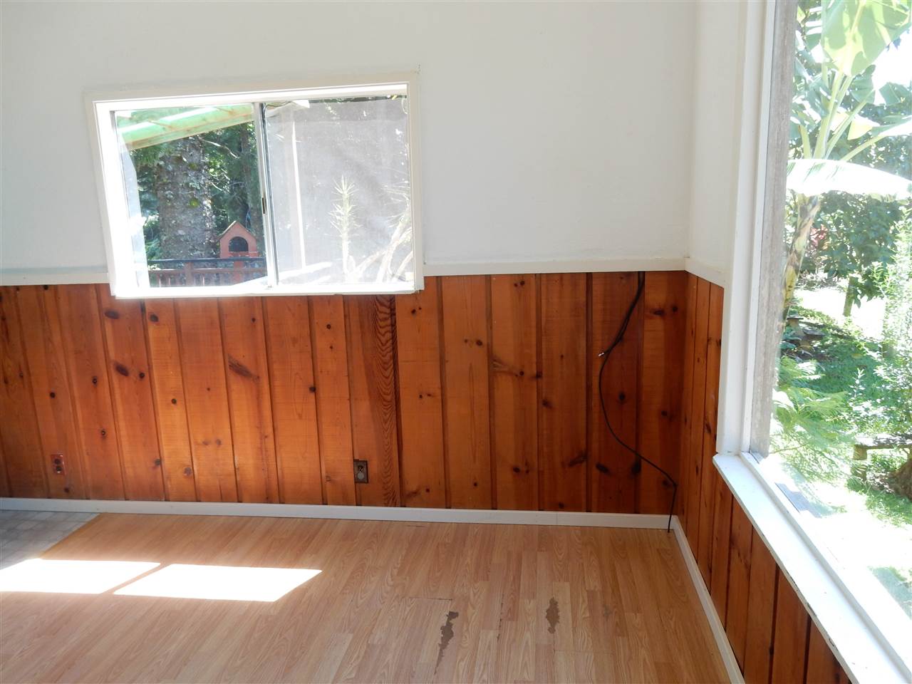 1661 West Kuiaha Road Haiku, HI 96708 - Photo 8 of 16 an empty room with wooden floor and windows
