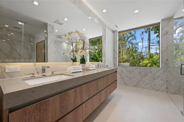 a bathroom with a glass shower door and a sink