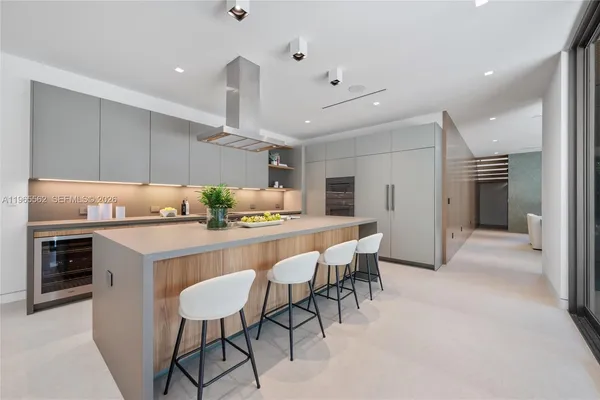 a kitchen with kitchen island a stove a table and chairs in it