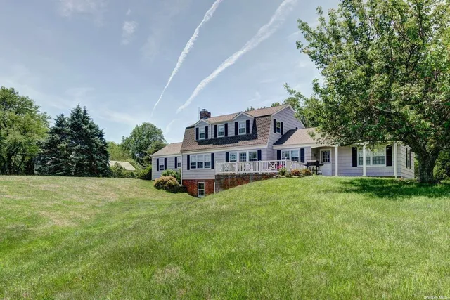 a view of a house with a big yard plants and large trees