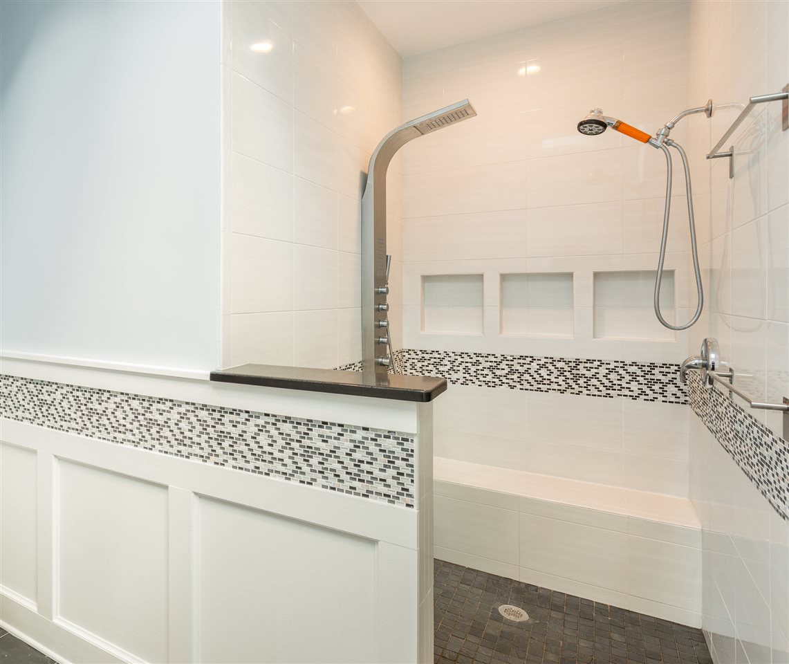 4409 Wood Valley Drive Raleigh, NC 27613 - Photo 20 of 30 The glass free shower( yes, no glass to clean!) offers tile surround, three shower niches, dual shower heads(one with body sprays), and slate flooring. Wonderful Walk-in Shower with Dual Shower Heads