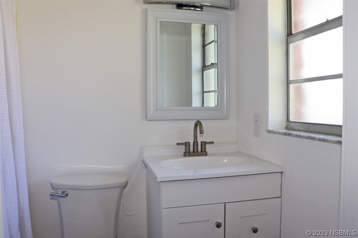 10 Raintree Drive Port Orange, FL 32127 - Photo 16 of 31 a bathroom with a sink a vanity and a window