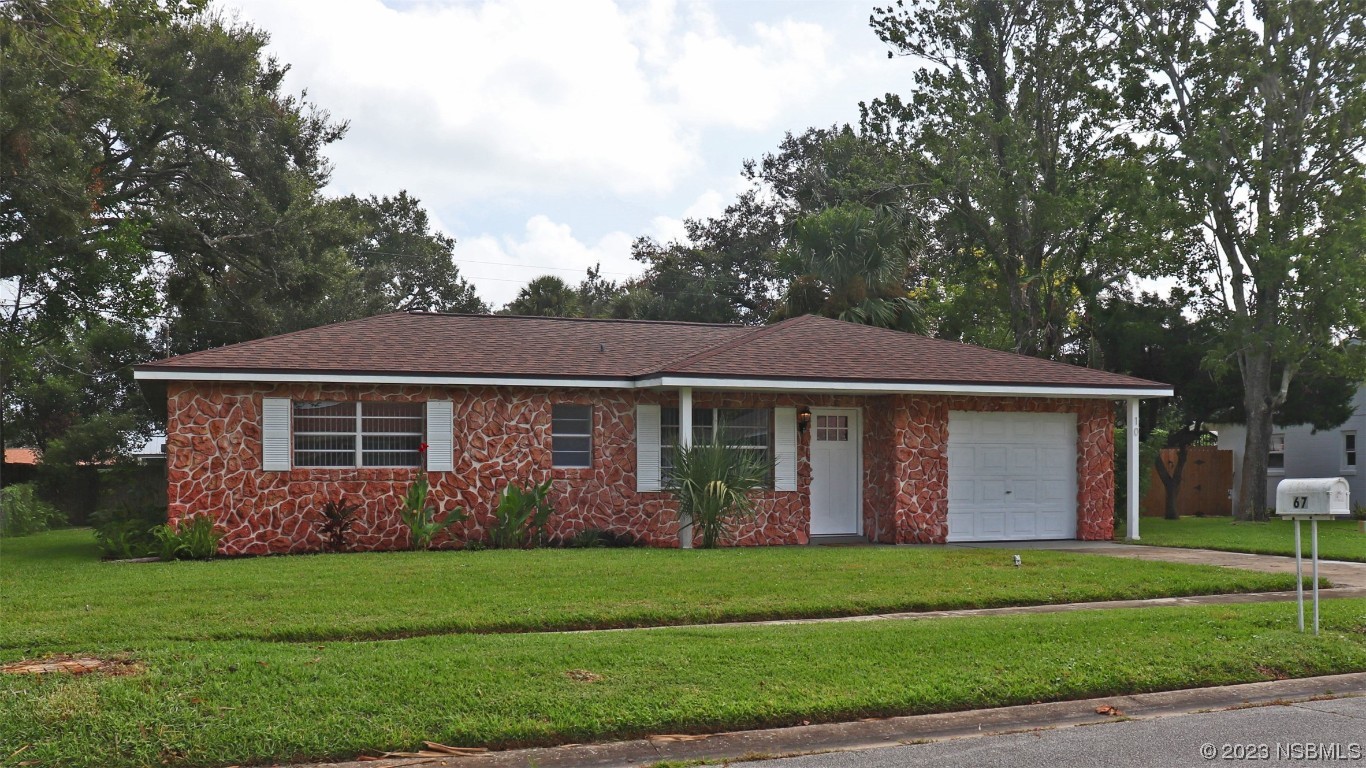 10 Raintree Drive Port Orange, FL 32127 - Photo 2 of 31 a view of a house with brick walls and a yard with plants and large trees